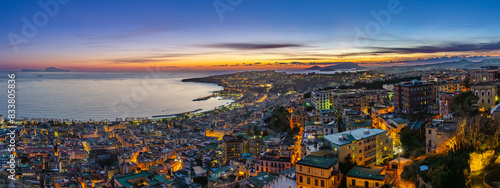 Naples, Italy. View of the city from Castel Sant'Elmo, with the Northern side of the Gulf of Naples at sunset. City lights at dusk. Banner Header image. photo