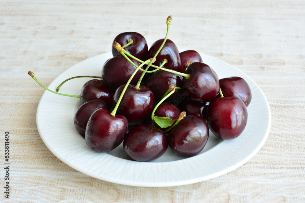 cherries with stems on the white plate close up cherries with stems on the white plate close up