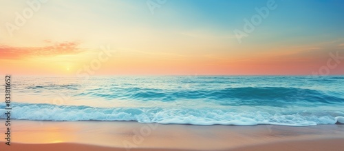 Golden sand beach with clear blue ocean and a sunset in the background  ideal for a summer or spring abstract background with copy space image.