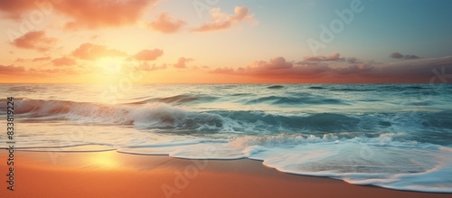 A breathtaking image of a serene beach at sunset with ocean waves, offering a peaceful paradise vibe and plenty of copy space image. © vxnaghiyev