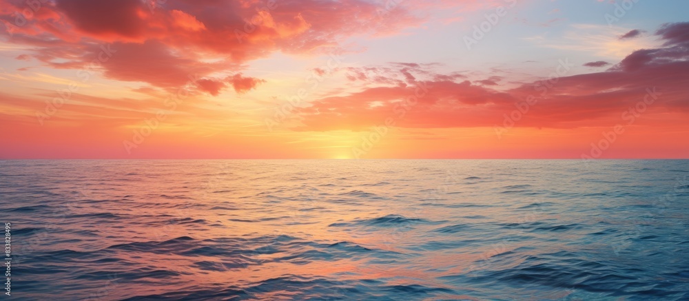 Fototapeta premium Vivid sunset over the tranquil sea, offering ample copy space image.