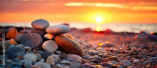 A small pile of rocks on the beach with the sunset casting a warm glow. Background intentionally blurred to allow for copy space image. photo