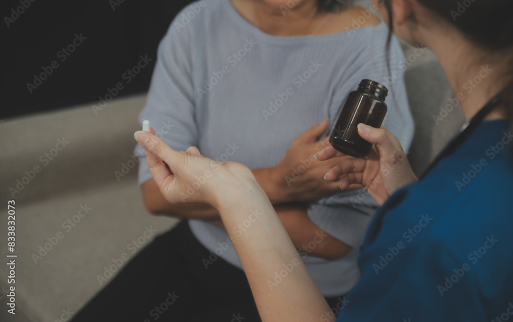 Female caregiver doing regular check-up of senior woman in her home.