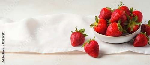 Fresh strawberries with sweet cream on a natural cotton napkin, complemented by a serene copy space image. photo