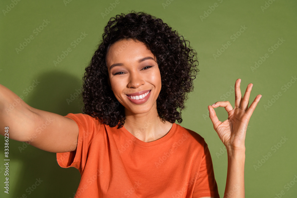 Photo portrait of lovely young lady selfie photo okey gesture dressed stylish orange garment isolated on khaki color background Photo portrait of lovely young lady selfie photo okey gesture dressed stylish orange garment isolated on khaki color background
