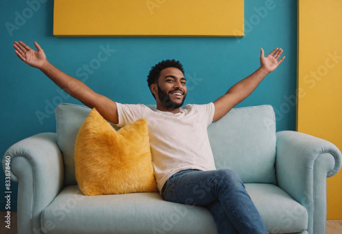 Man in white t-shirt with open arms happy sitting on a sofa