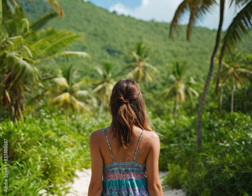 Rear view of a young tourist girl enjoying amazing beauty of tropical nature, active life on exotic island