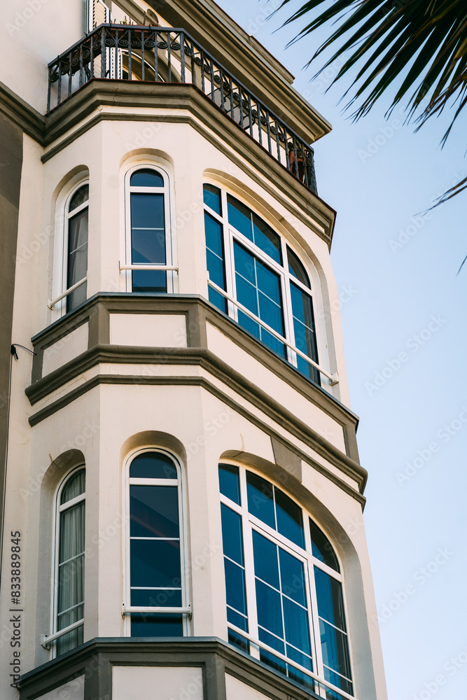 Elegant Corner Building with Large Blue Windows and Balcony