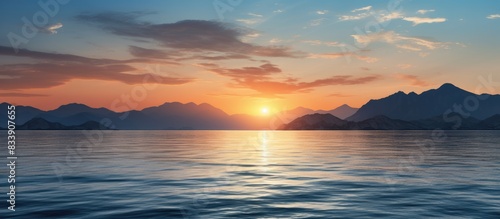 A scenic seascape at sunset with mountains in the backdrop  ideal for a copy space image.