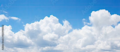 Fluffy white clouds against a blue sky with copy space image.