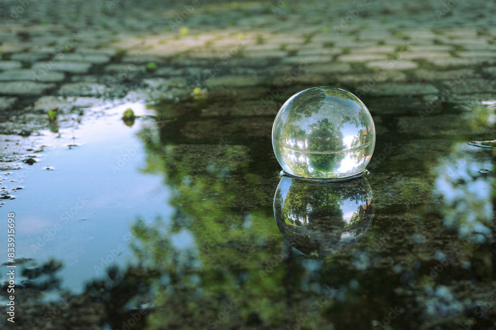 Close up of a crystal ball in a puddle of water Close up of a crystal ball in a puddle of water