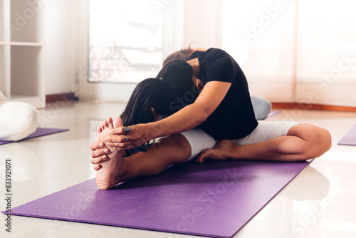 Young woman in class practicing the yoga pose Janu Sirsasana: The Head to Knee photo
