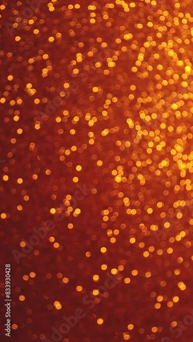 Bokeh vertical background of vibrant gold colors. Changing tiny yellow circles on brown back. Holidays New Year and party concept with copy space.