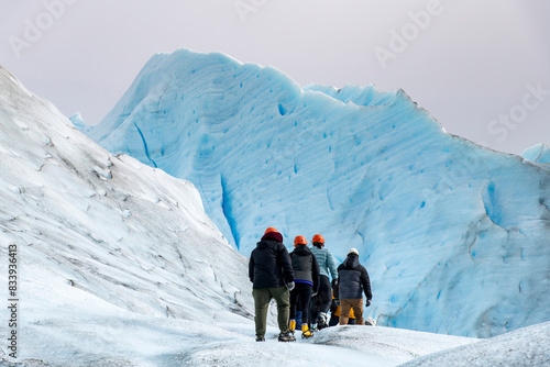 Bild auf Leinwand Group of people walking on crampons between high ice walls on the terminus of th