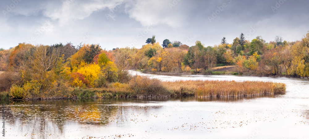 Obraz premium Autumn landscape with colorful trees on the banks of the river