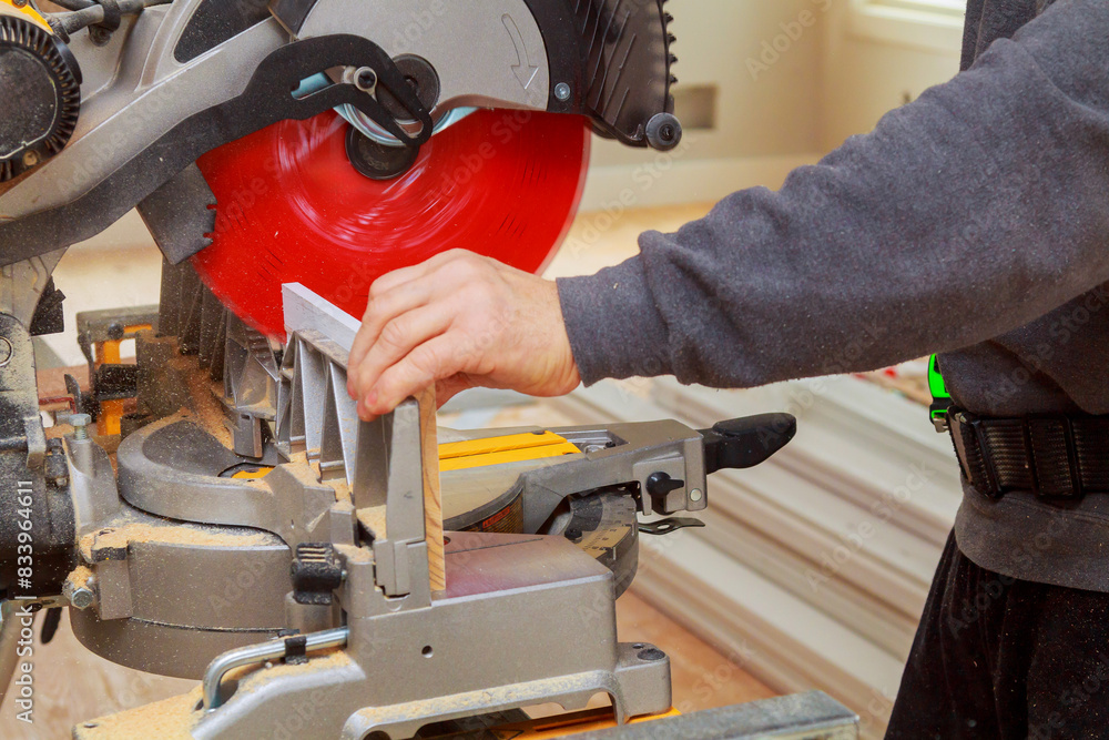 Contractor of using circular saw is cutting wooden moldings on circular saw before installing Contractor of using circular saw is cutting wooden moldings on circular saw before installing