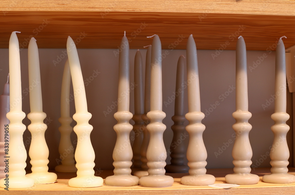 Fototapeta premium A burning wax candle stands on the table.