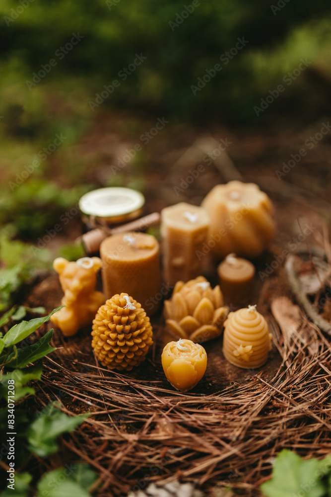 Handmade candles from natural beeswax in the shape of bear, pine cone and others, jars of honey. Hobby. Beekeeping. Artistic photo of beekeeping products against the backdrop of nature, forest Handmade candles from natural beeswax in the shape of bear, pine cone and others, jars of honey. Hobby. Beekeeping. Artistic photo of beekeeping products against the backdrop of nature, forest