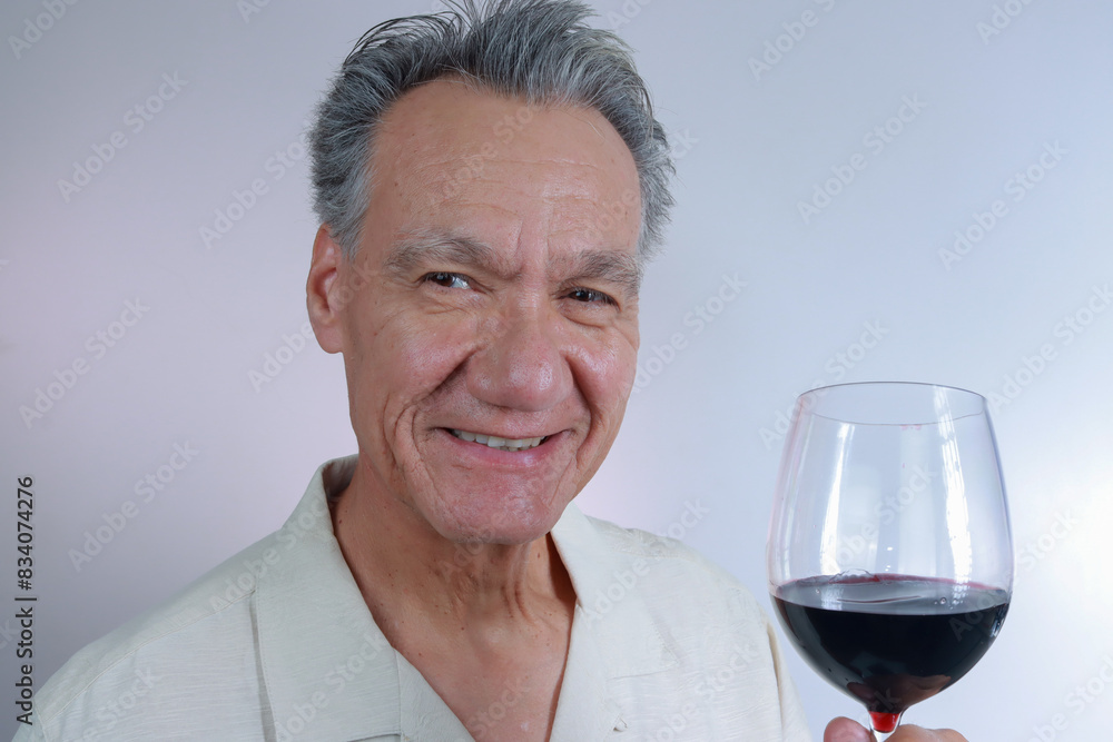 Mature Man smiling and holding up a big glass of red wine Mature Man smiling and holding up a big glass of red wine