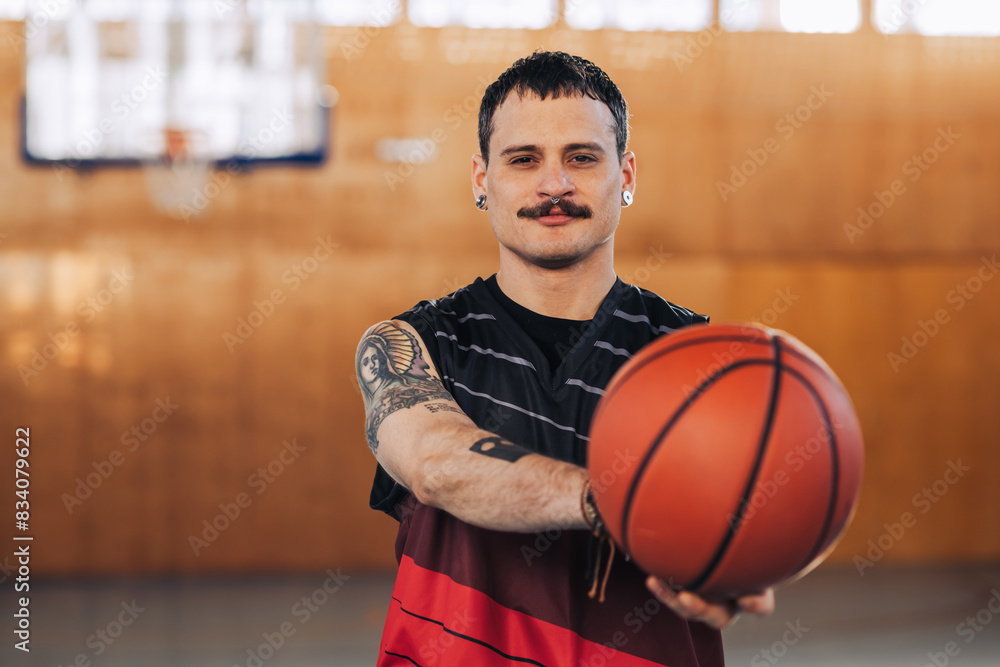 Handsome tattooed hispanic male basketball player with a ball in his hands Handsome tattooed hispanic male basketball player with a ball in his hands