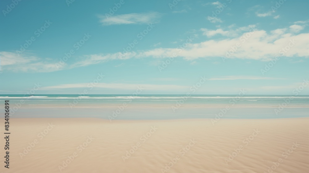 A pristine sandy beach with clear blue skies and calm ocean waves A pristine sandy beach with clear blue skies and calm ocean waves