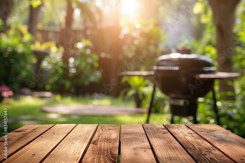 A close-up of an empty wooden table with a blurred garden background and a grill in the distance