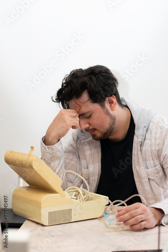 Person with respiratory problems in the living room trying to used a old nebulizer and get confused