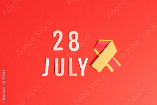 Yellow-red ribbon with wooden numbers July 28. photo