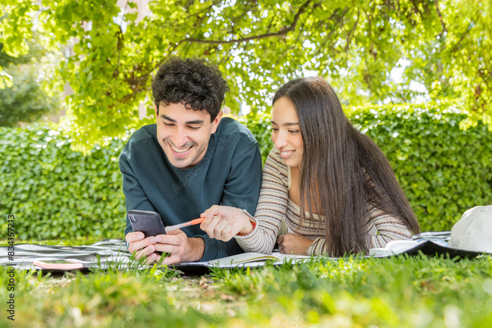 Young couple enjoying with smartphone in park Young couple enjoying with smartphone in park