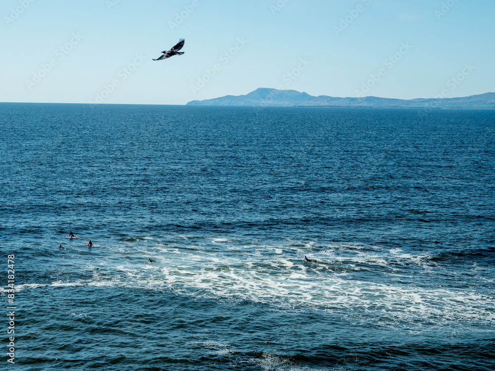 A beautiful Bundoran sandy beach with a green grassy field and a blue ocean. The sky is cloudy, but the beach is still a peaceful and relaxing place. Popular travel tourist area in Ireland. Sunny day.