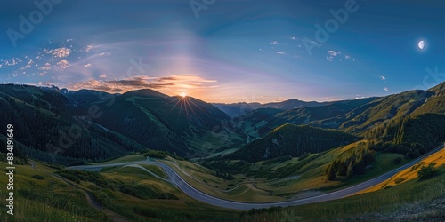 A scenic view of a winding road set against the backdrop of a sunset over the mountains