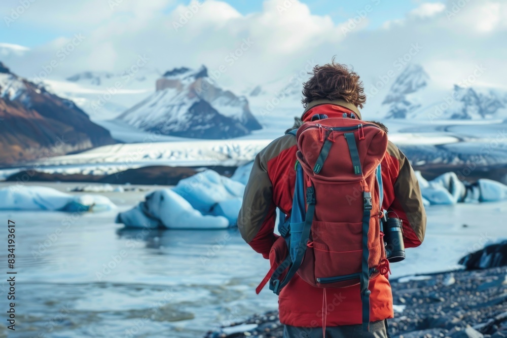 A person standing by the edge of a glacier, looking out at the breathtaking view A person standing by the edge of a glacier, looking out at the breathtaking view