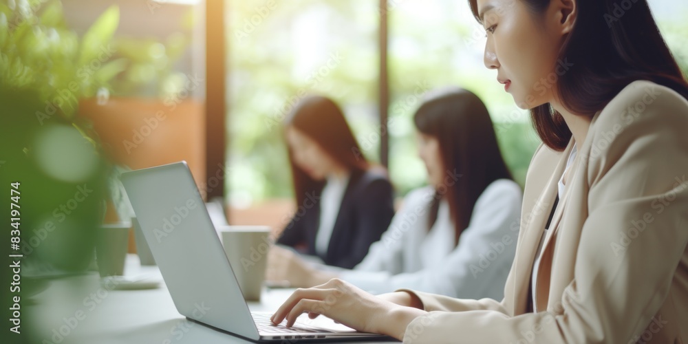A woman sits at a table using a laptop computer A woman sits at a table using a laptop computer