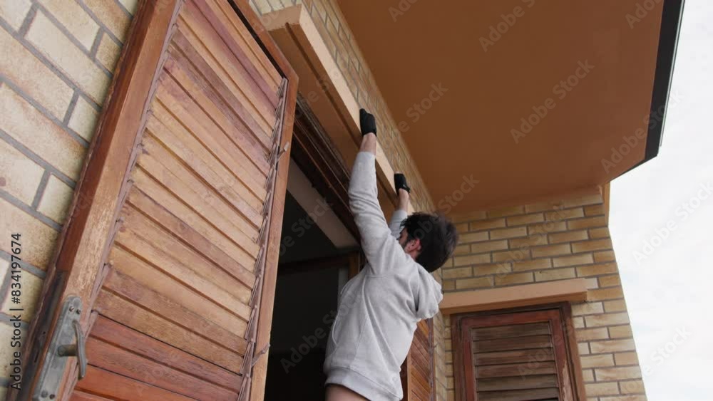 Man Does Pull-ups Exercises On The Window At Home Man Does Pull-ups Exercises On The Window At Home