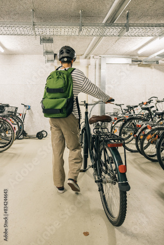 Girl with green backpack going out with her bicycle