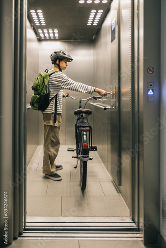 Teenager in the elevator with his bicycle, morning routine concept