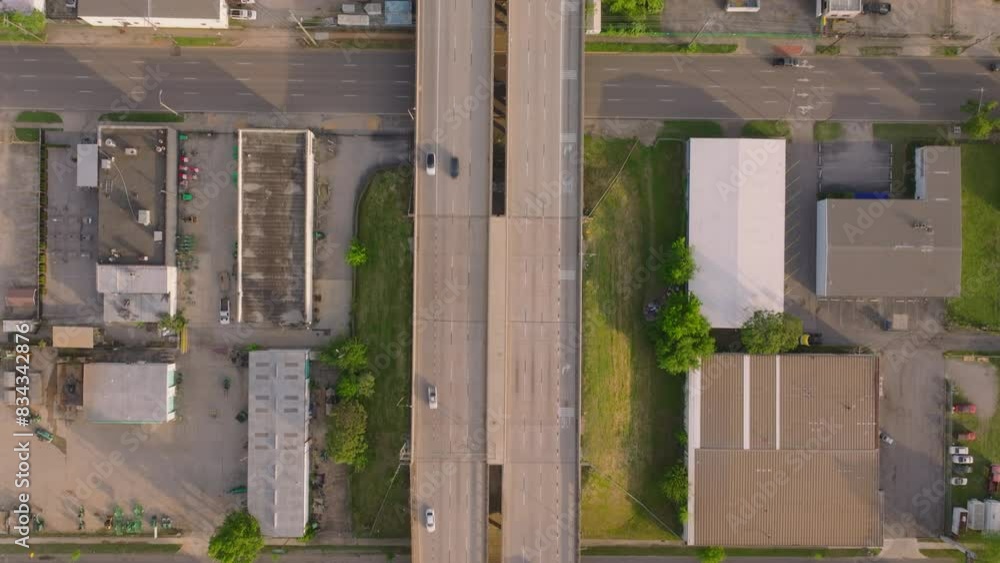 Bird's eye view of a highway intersection with cars traffic, industrial buildings, and landscape, showcasing urban development and transportation system Bird's eye view of a highway intersection with cars traffic, industrial buildings, and landscape, showcasing urban development and transportation system