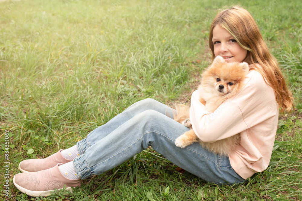 Fototapeta premium cute girl plays with a dog in nature. pets in the family