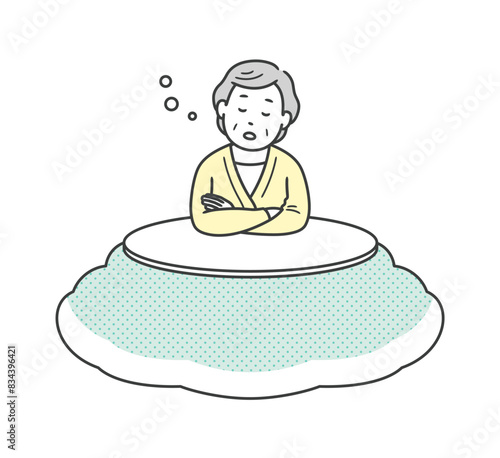 こたつに入って居眠りをする高齢女性
