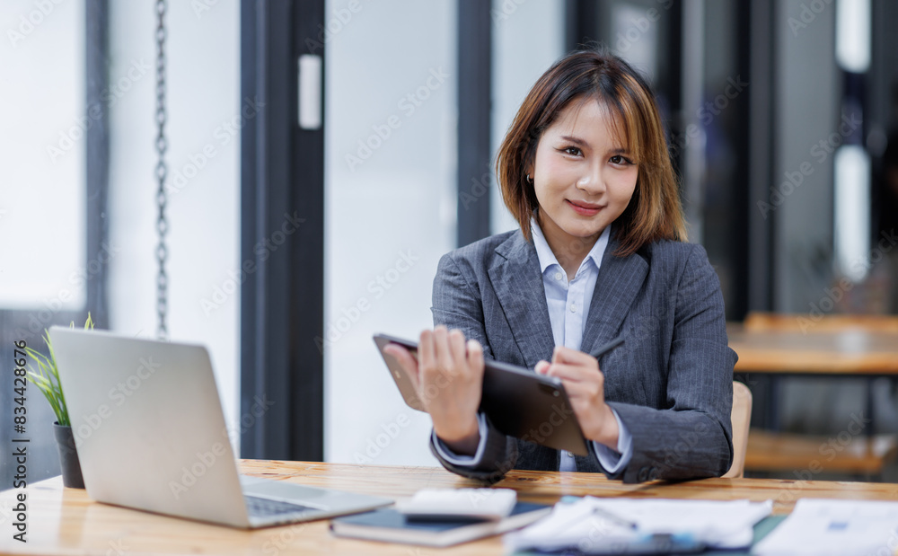 Asian Businesswoman Using laptop computer and working at office with calculator document on desk, doing planning analyzing the financial report, business plan investment, finance analysis concept.
Asian Businesswoman Using laptop computer and working at office with calculator document on desk, doing planning analyzing the financial report, business plan investment, finance analysis concept.