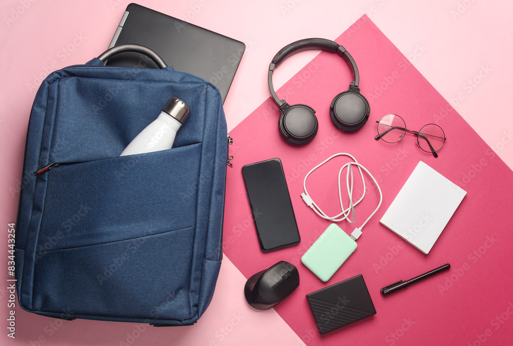 Laptop with Modern gadgets and accessories for work and study in Backpack on pink background. Top view. Flat lay Laptop with Modern gadgets and accessories for work and study in Backpack on pink background. Top view. Flat lay