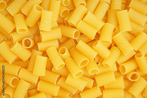 Delicious uncooked penne pasta as background