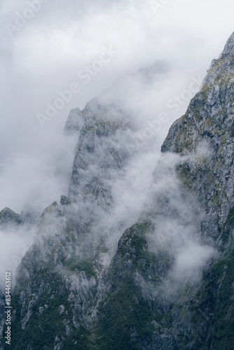 Glacial mountains covered in misty cloud in Milford Sound, Fiordland, New Zealand.