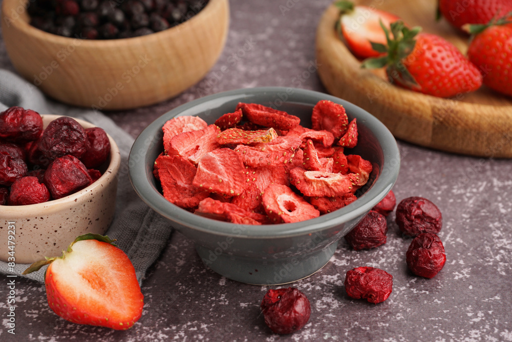 Bowl with freeze-dried strawberry and cherries on grey background Bowl with freeze-dried strawberry and cherries on grey background