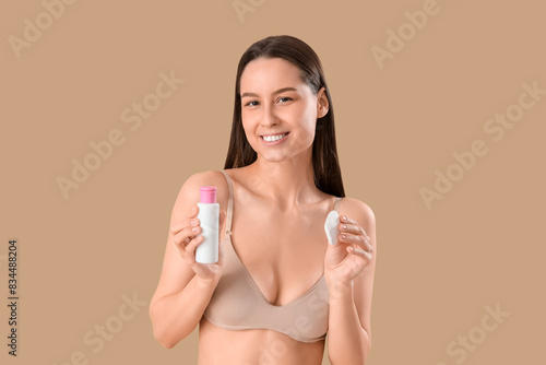Young woman with cotton pad...