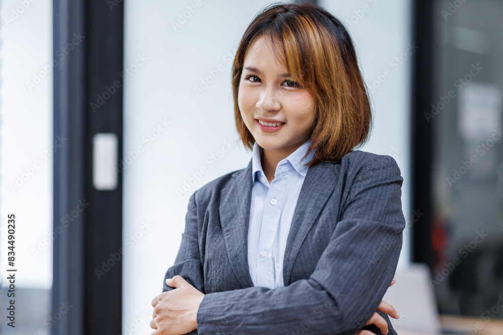 Young Asian business woman smiling confidently while standing alone in a bright modern office
Young Asian business woman smiling confidently while standing alone in a bright modern office