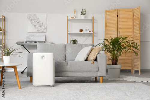 Modern humidifier near sofa in stylish living room photo