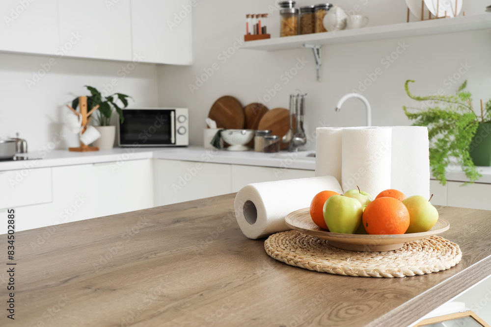 Rolls of paper towels with fruits on table in kitchen, closeup Rolls of paper towels with fruits on table in kitchen, closeup