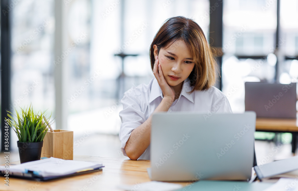 Portrait of happy asian female employee at computer