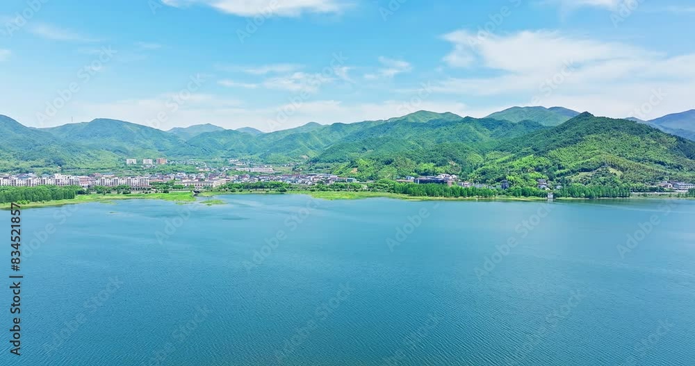 Aerial view of clear lake and green mountain natural landscape in Ningbo, Zhejiang Province, China. Beautiful lake and residential buildings with mountain landscape in summer. Aerial view of clear lake and green mountain natural landscape in Ningbo, Zhejiang Province, China. Beautiful lake and residential buildings with mountain landscape in summer.